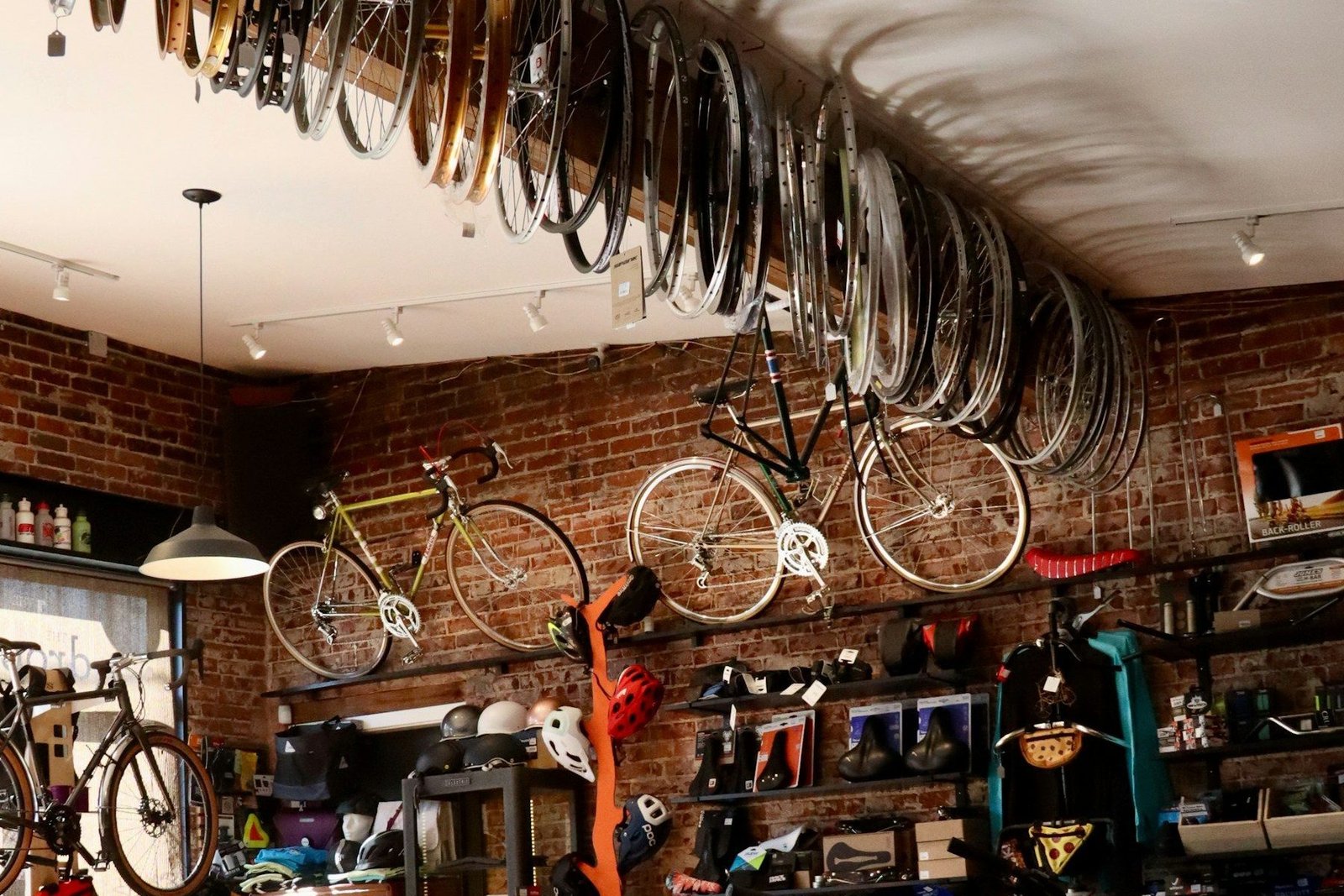 The interior of a bicycle workshop with bikes hanging from the walls and ceiling