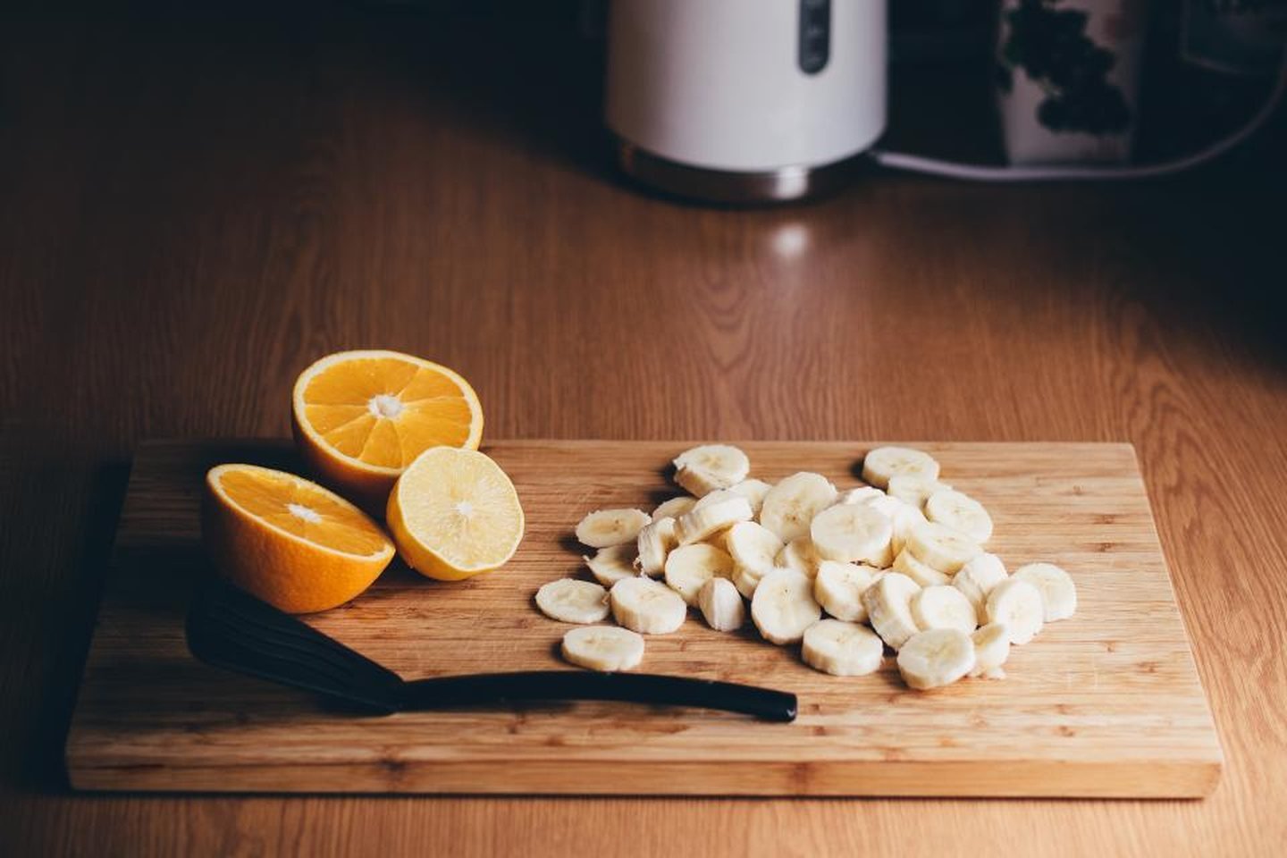 Sliced bananas and halved oranges on a wooden board, prepared as food for a ride