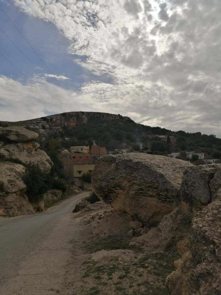 A narrow road leading into a hillside village below the cliffs of Moulay Idriss Zerhoun